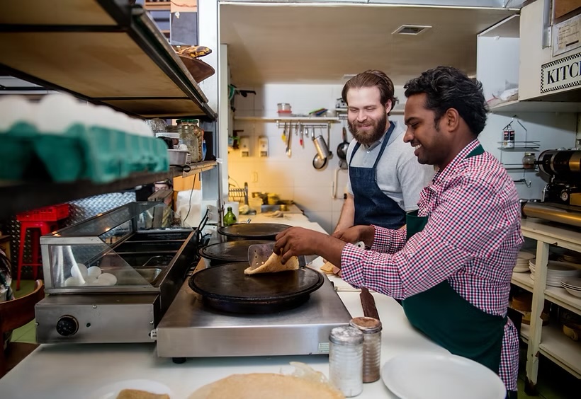 Chefs making crepes in a busy kitchen